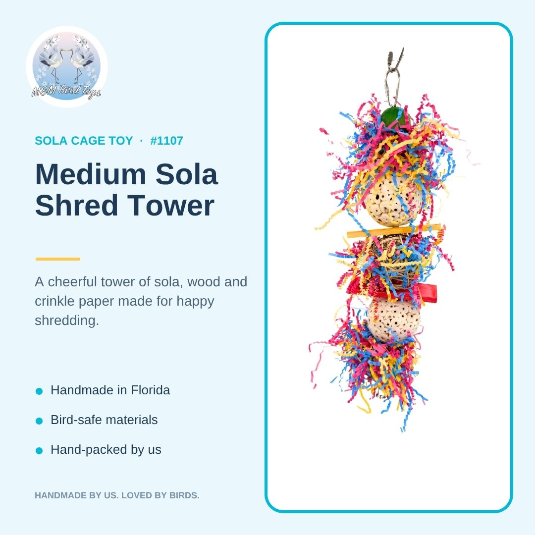 A hanging bird toy made of three beige speckled balls stacked vertically, wrapped in bright multicolored shredded paper and string, with small wooden bars and a red bead. Its on a graphic template with information.